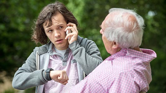 Anthony calls 999 and is looking at his watch. Mae Anthony yn ffonio 999 ac yn edrych ar ei oriawr. 